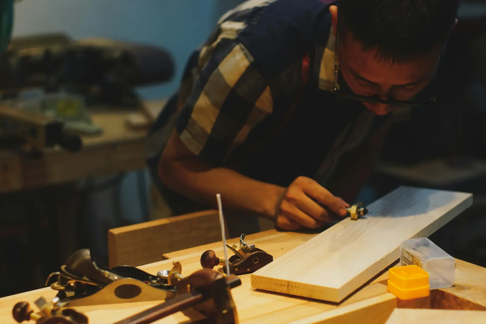 Cursist werkt aan een houten plank met handgereedschap